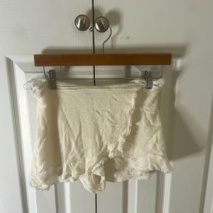 White skirt with shorts underneath. Has almost polka dot sewing’s on it